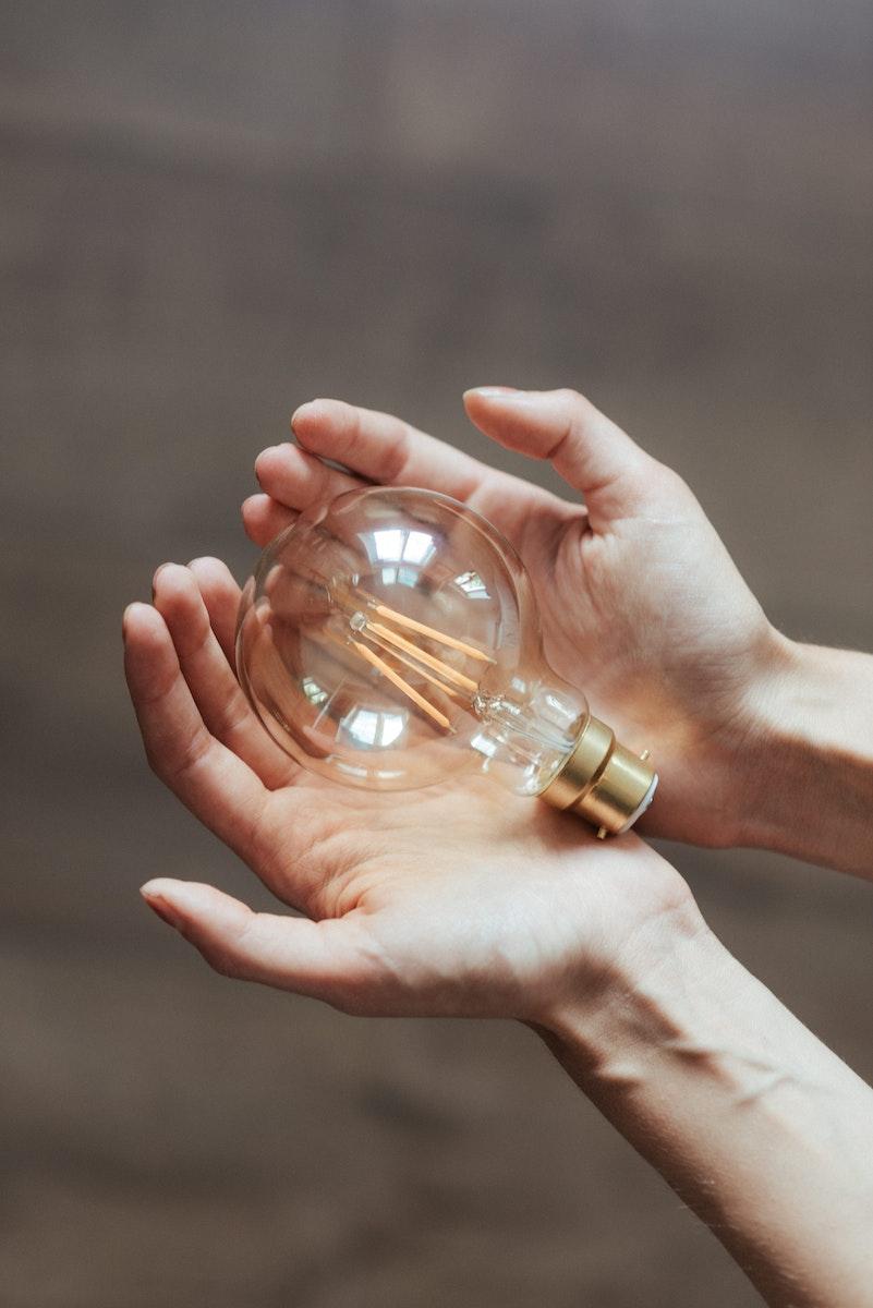 Photo by Anete Lusina Unrecognizable woman demonstrating light bulb in hands