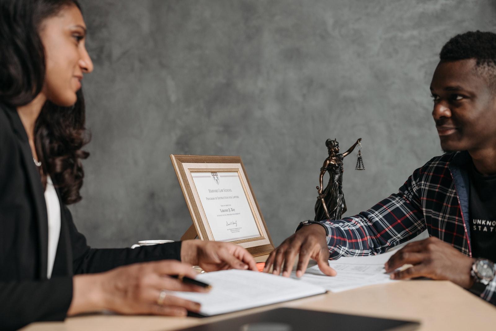 Photo by Pavel Danilyuk A Man and a Woman Sitting at the Office Table with White Paper in Front