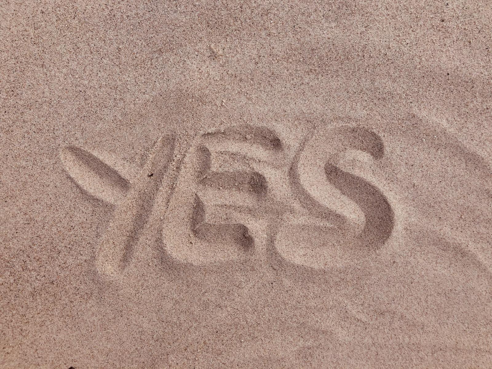 Photo by Drahomír Posteby-Mach yes text on brown sand