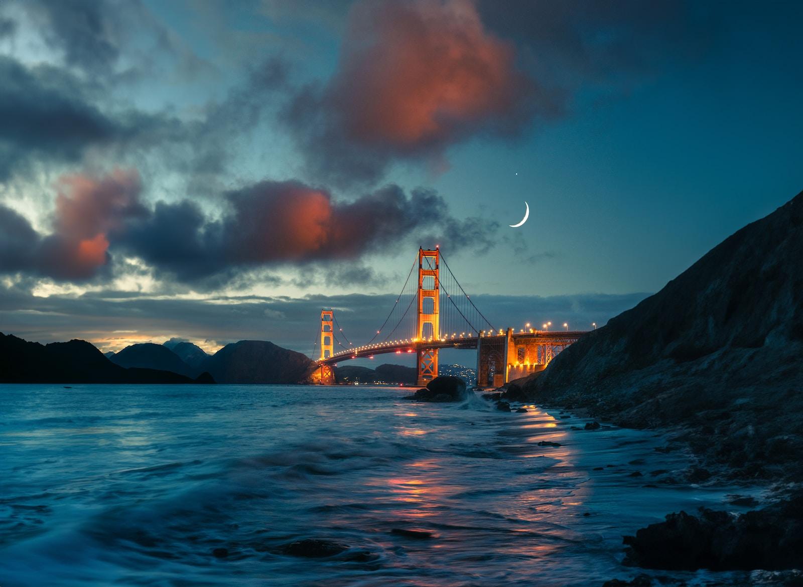 the golden gate bridge is lit up at night